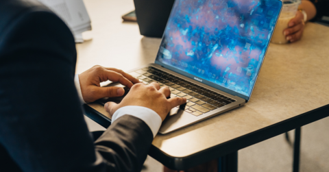 Male student typing on laptop