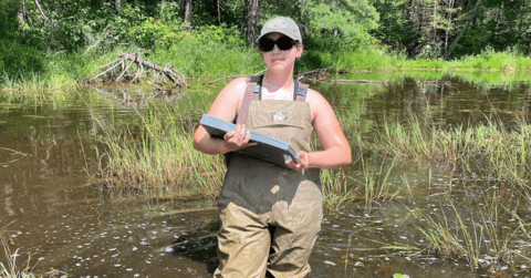 Sam Terry standing in water wearing waders