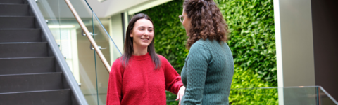 Two students talking indoors