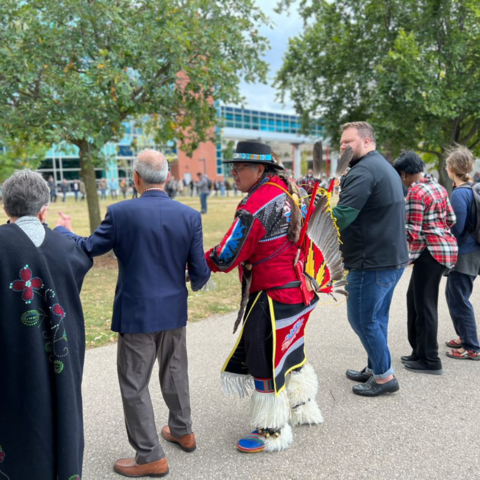 Members of the UW campus community holding hands and participating in a round dance